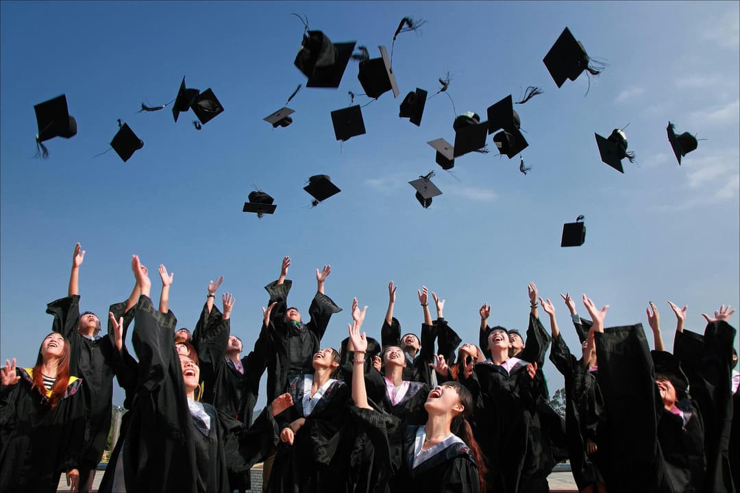 Graduates throwing their graduation hats.