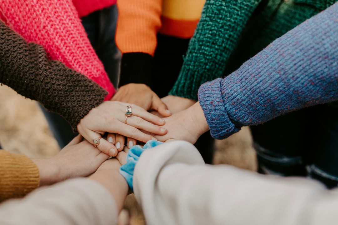 A community stacking their hands on top of each other.